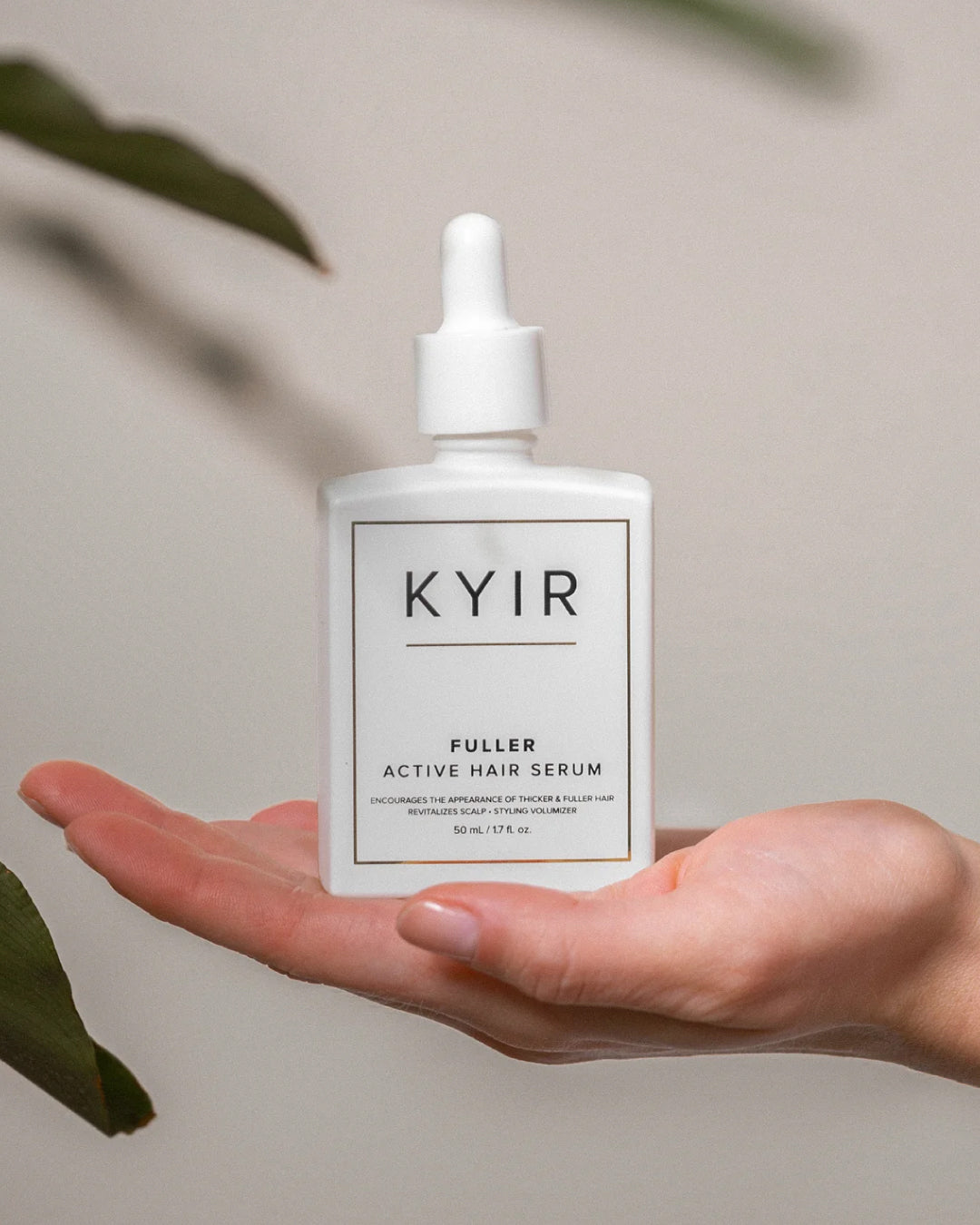 Kyir Fuller Active Hair Serum bottle held in a hand