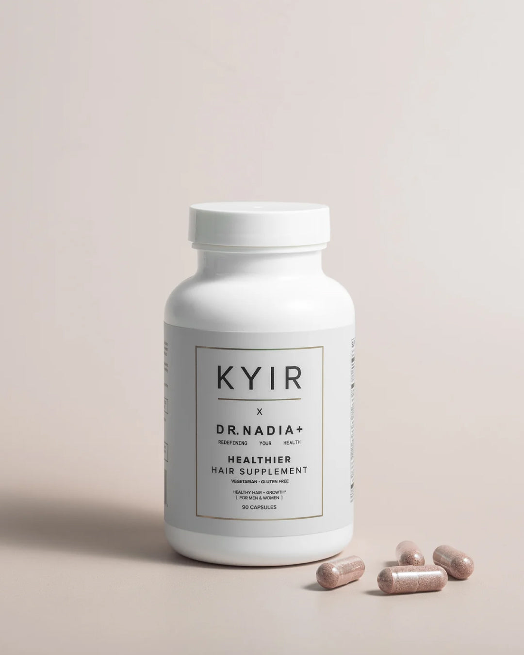 Kyir The Kyir Method Healthier Hair Supplement bottle with four capsules on a light background